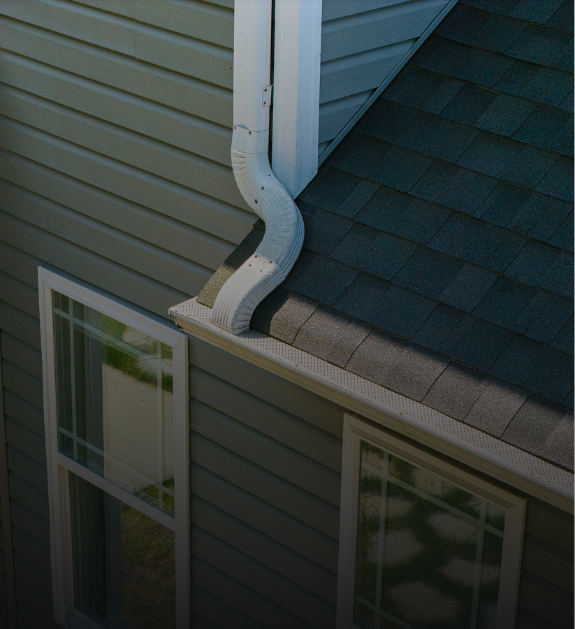 House roof corner with gutter and windows.